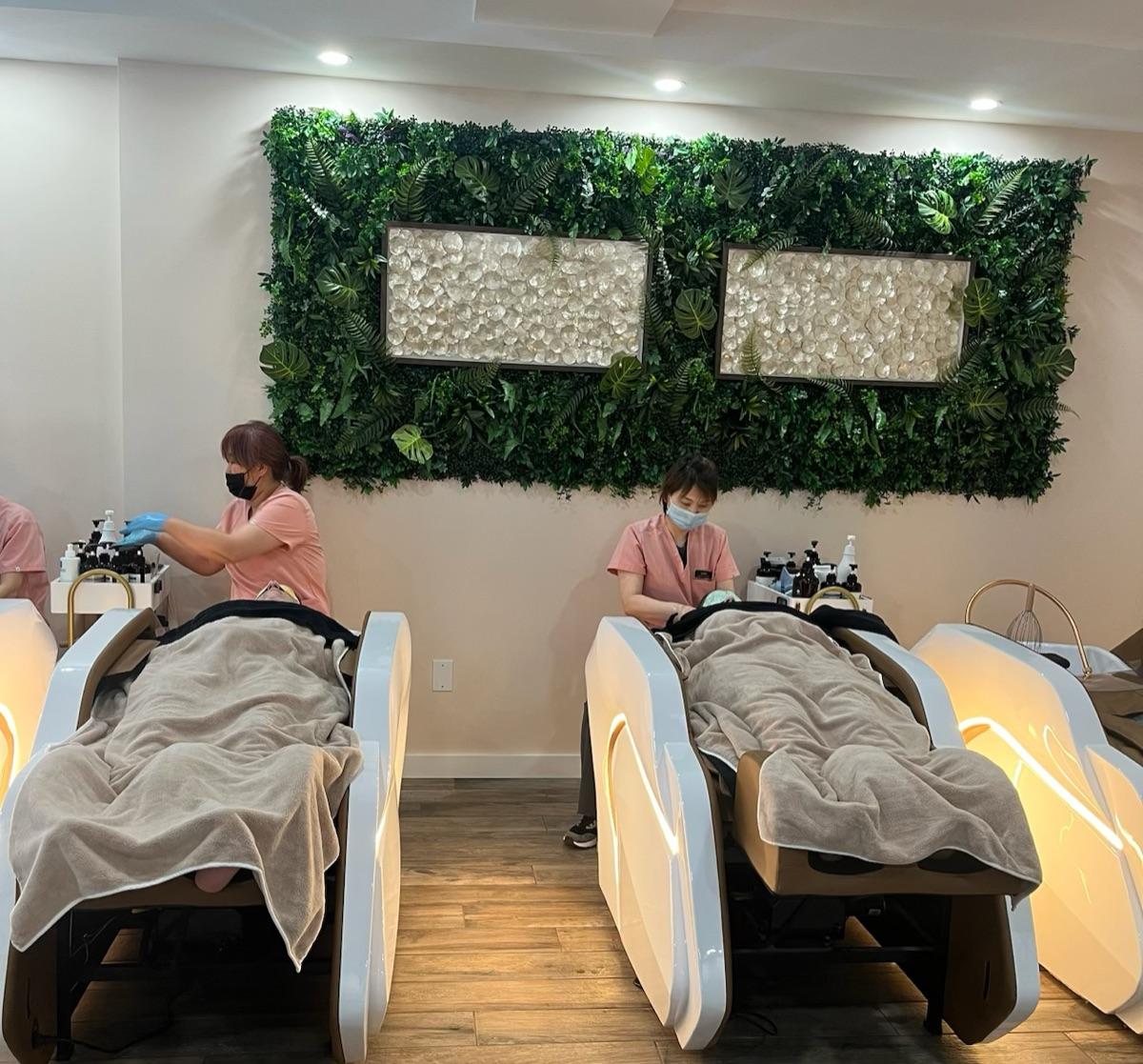 Two guests receiving head spa treatments on the studio's massage beds
